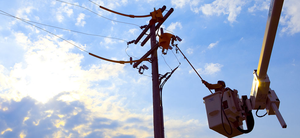 Electric worker in a bucket truck working on power pole