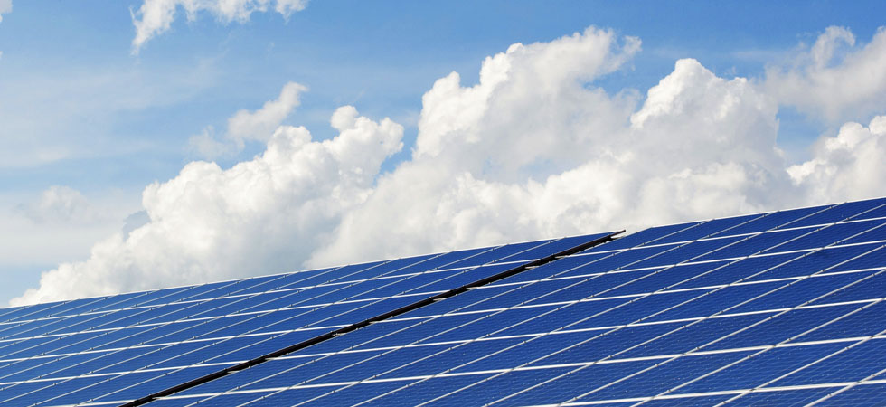 Bank of solar panels with clouds in the background