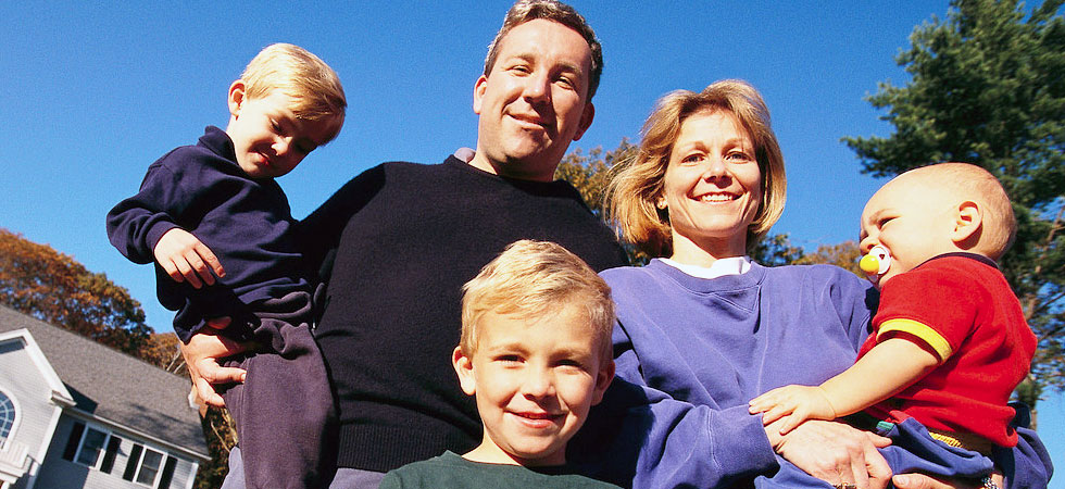 Family of five standing outside their house