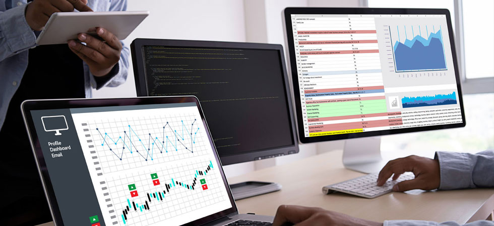 multiple computer screens displaying reports and analytics