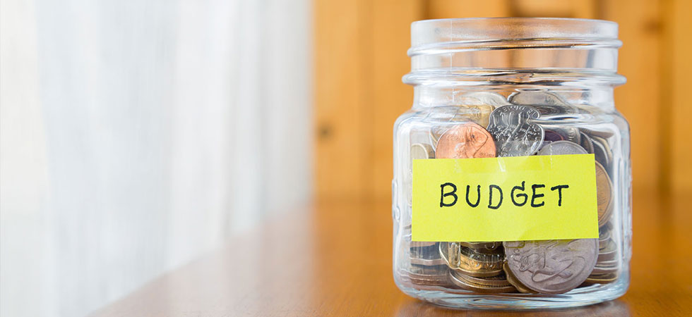 Glass jar full of coins labeled with budget