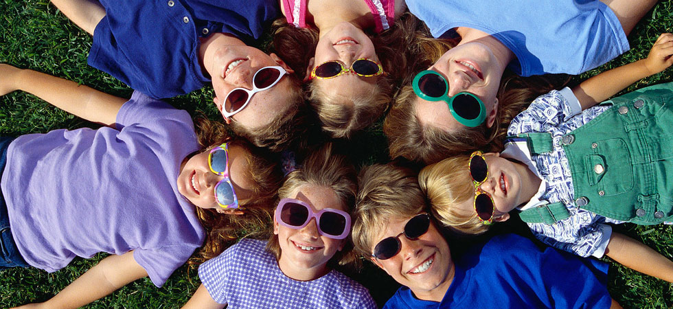 Group of kids laying in a circle looking up